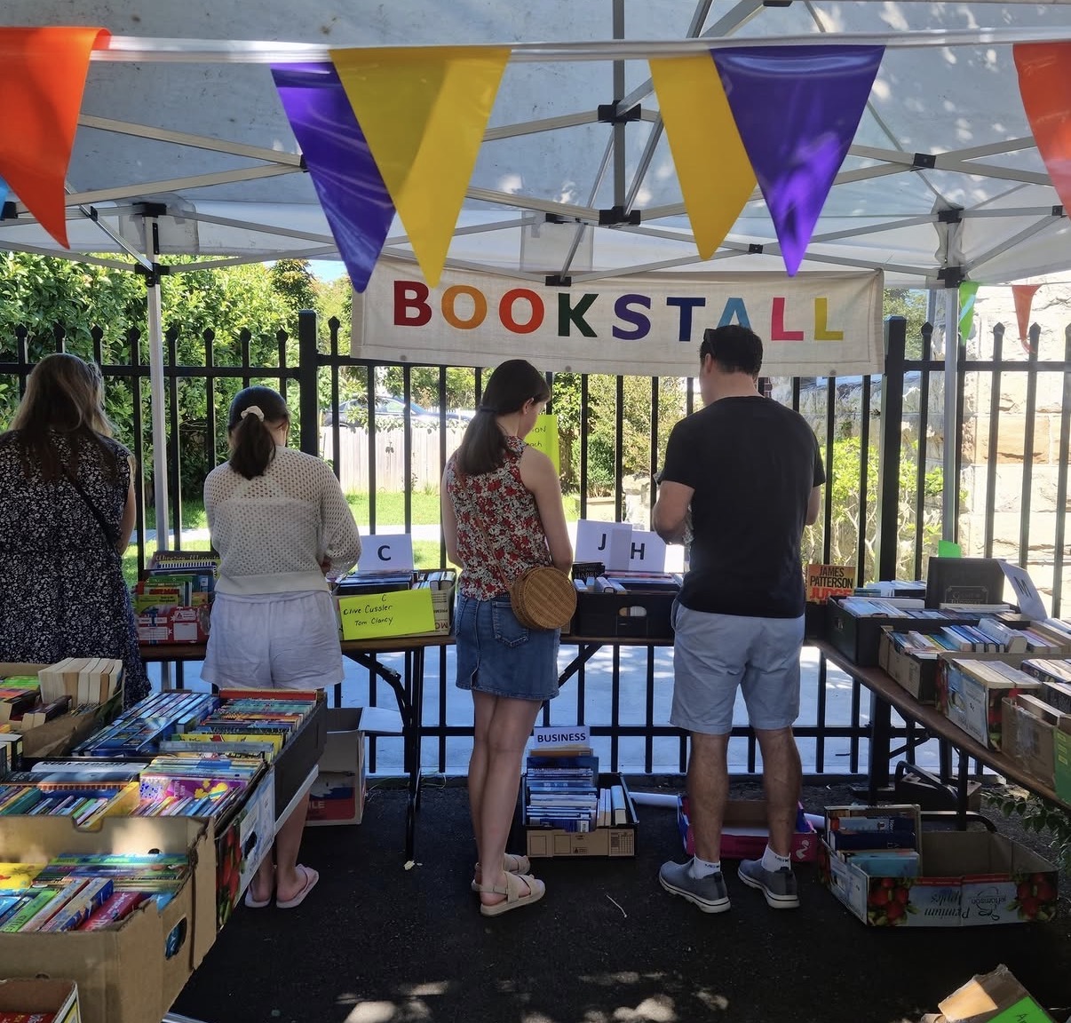 Visitors browsing the colourful pre-loved bookstall