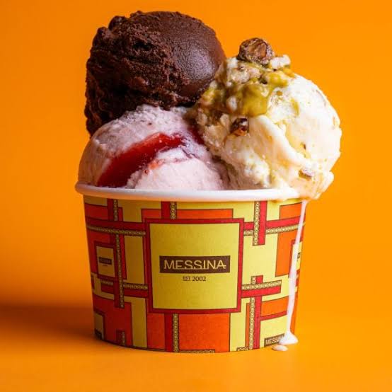 A Messina cup filled with scoops of chocolate, strawberry and pistachio gelato