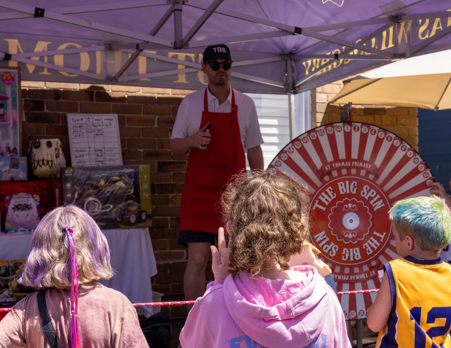 Families gathered around The Big Spin prize wheel at the St Thomas Art & Craft Show