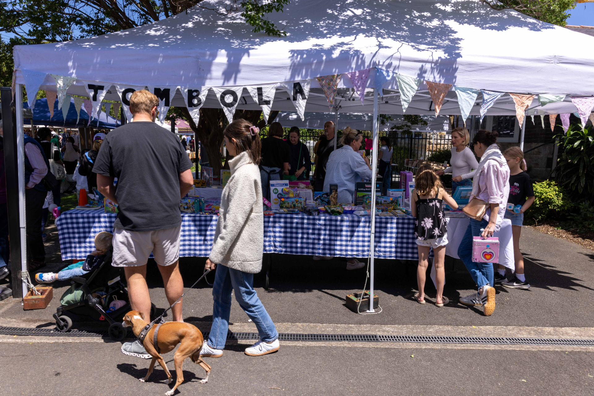 Families at the Tombola stall under a bunting-draped marquee