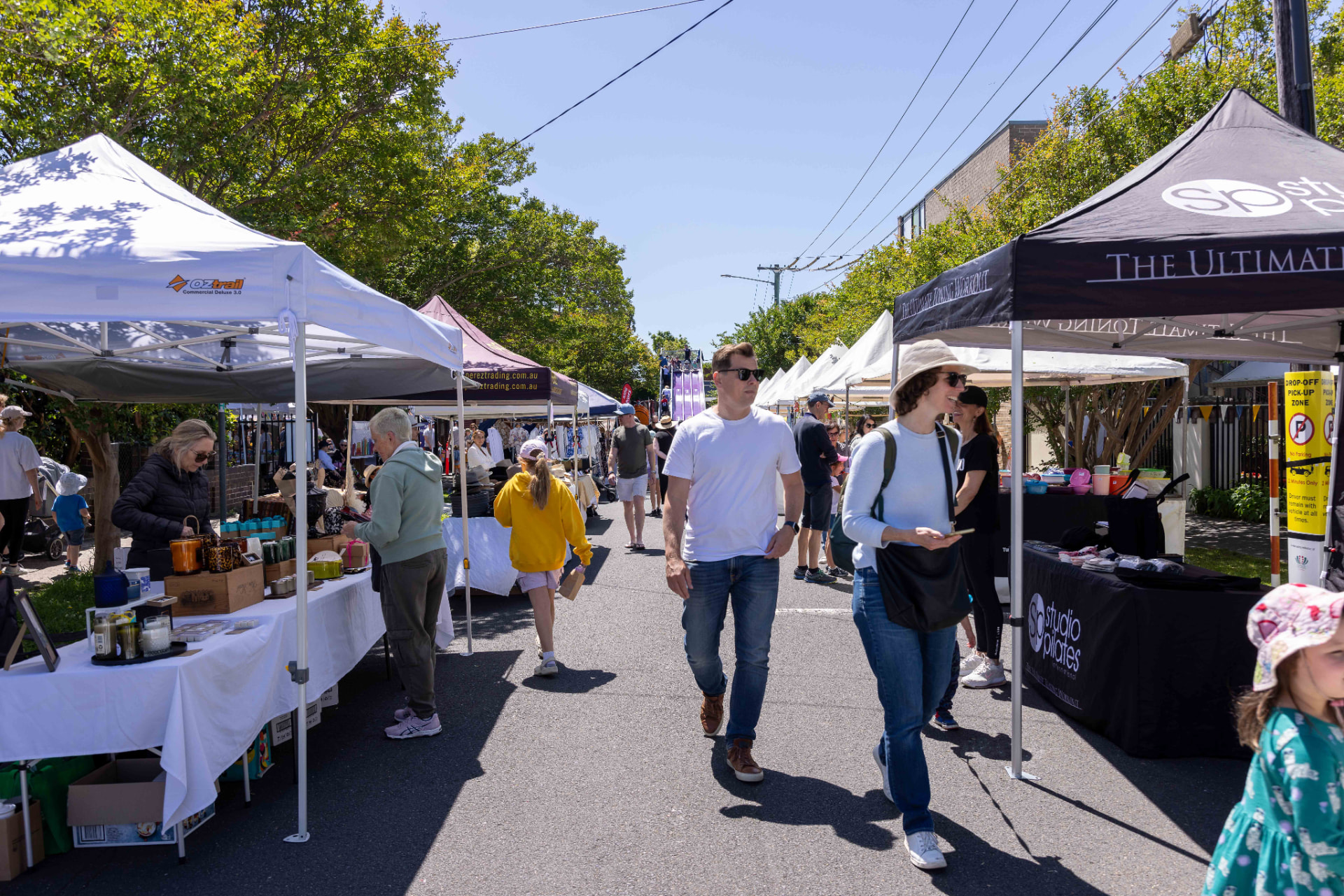 Shoppers browsing market stalls lining the street at the St Thomas Art & Craft Show