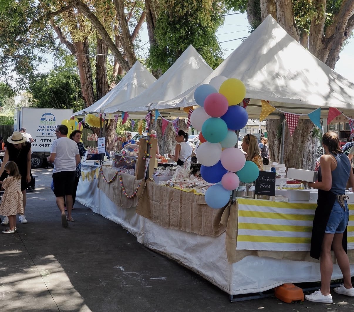 A colourful market stall with pastel balloons and bunting